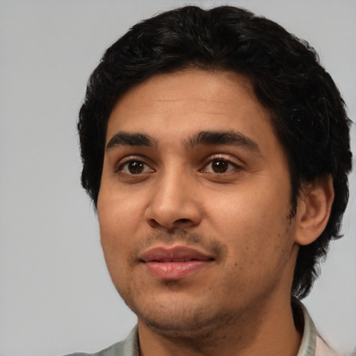 Joyful latino young-adult male with short  black hair and brown eyes