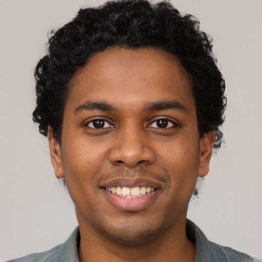 Joyful black young-adult male with short  black hair and brown eyes