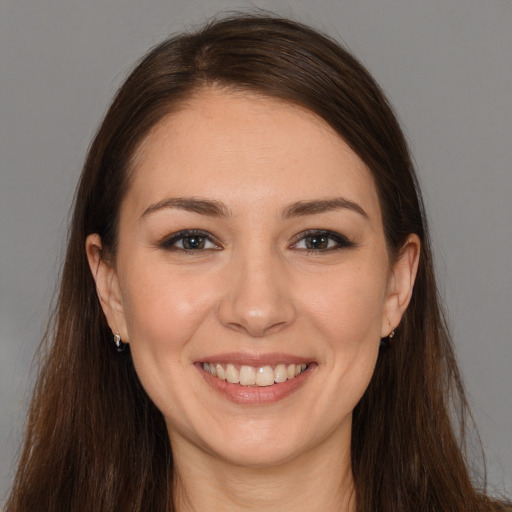 Joyful white young-adult female with long  brown hair and brown eyes