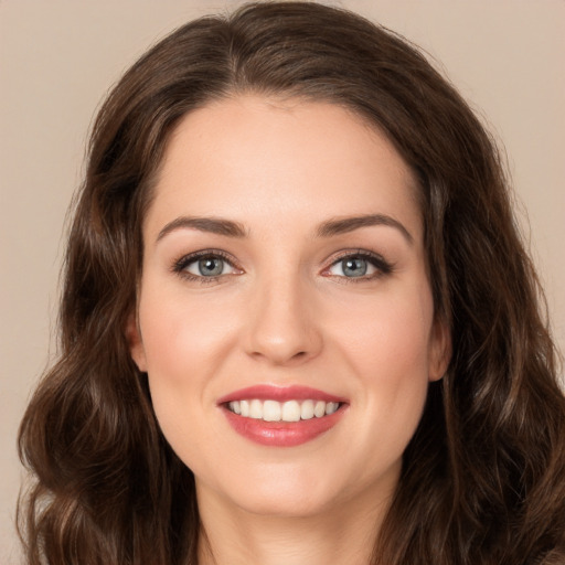 Joyful white young-adult female with long  brown hair and green eyes