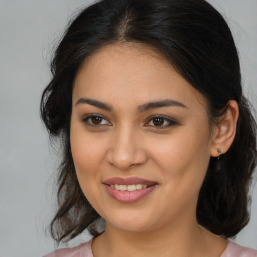 Joyful latino young-adult female with medium  brown hair and brown eyes