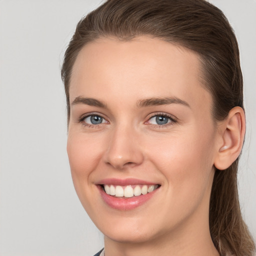 Joyful white young-adult female with long  brown hair and grey eyes