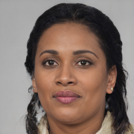 Joyful black adult female with long  black hair and brown eyes