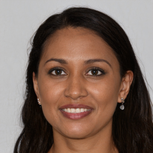 Joyful black young-adult female with long  brown hair and brown eyes