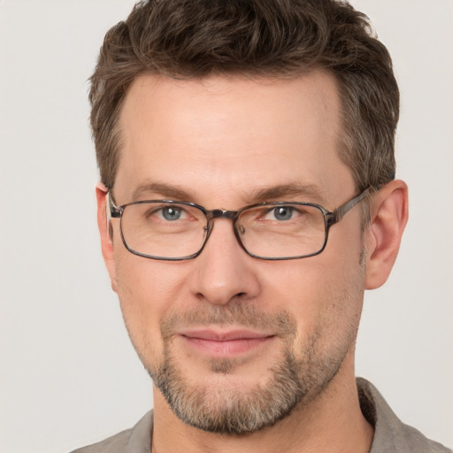 Joyful white adult male with short  brown hair and grey eyes