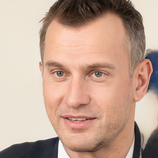 Joyful white adult male with short  brown hair and brown eyes