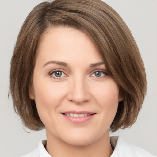 Joyful white young-adult female with medium  brown hair and green eyes