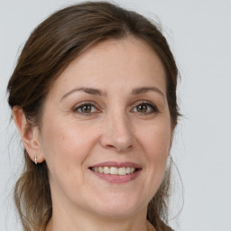 Joyful white young-adult female with medium  brown hair and grey eyes