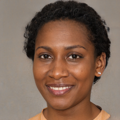 Joyful black young-adult female with short  black hair and brown eyes