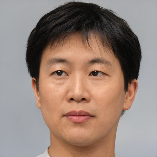 Joyful asian adult male with short  brown hair and brown eyes