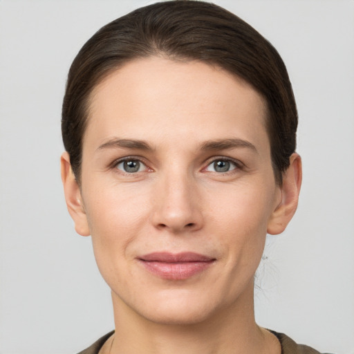 Joyful white young-adult female with short  brown hair and grey eyes