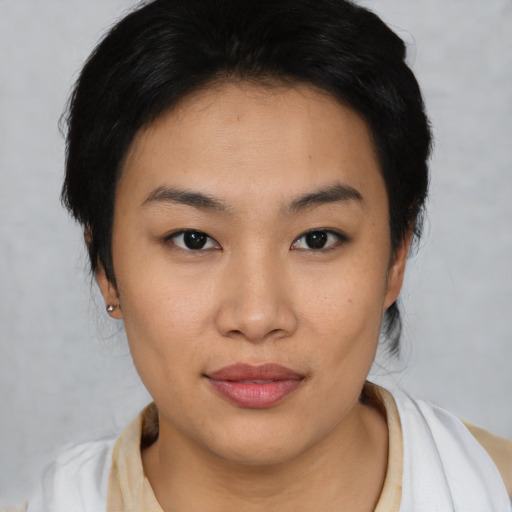 Joyful asian young-adult female with short  black hair and brown eyes