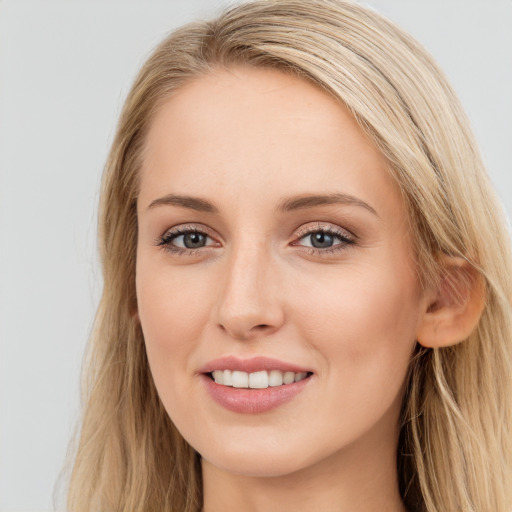 Joyful white young-adult female with long  brown hair and blue eyes