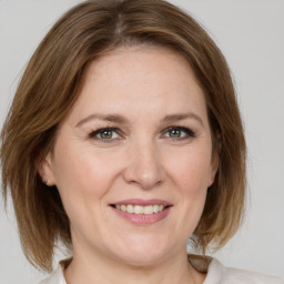 Joyful white adult female with medium  brown hair and grey eyes