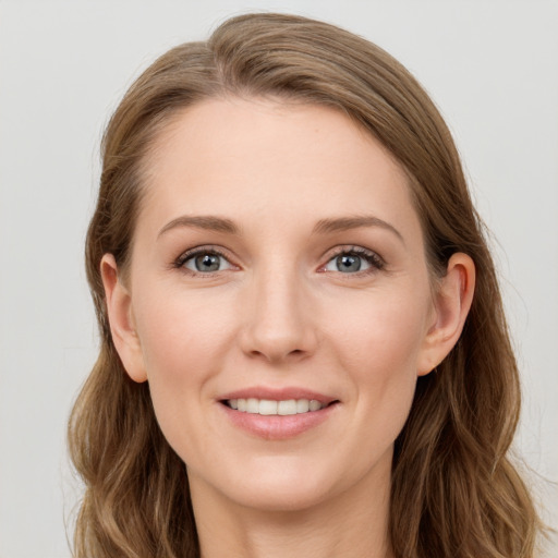 Joyful white young-adult female with long  brown hair and blue eyes