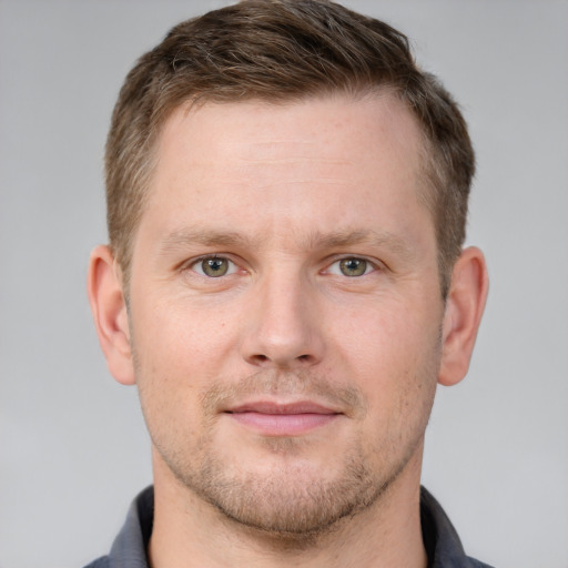 Joyful white adult male with short  brown hair and grey eyes