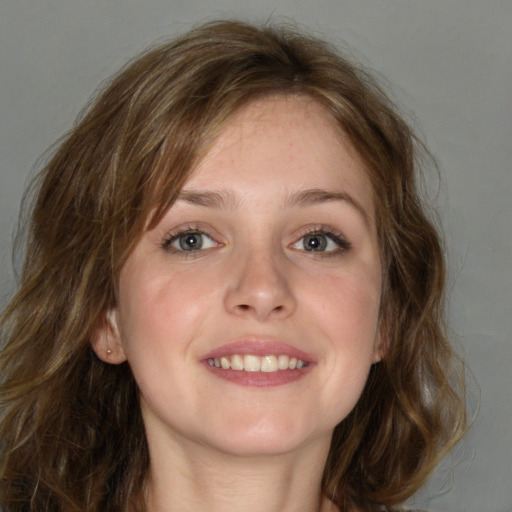 Joyful white young-adult female with long  brown hair and blue eyes