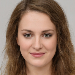 Joyful white young-adult female with long  brown hair and green eyes