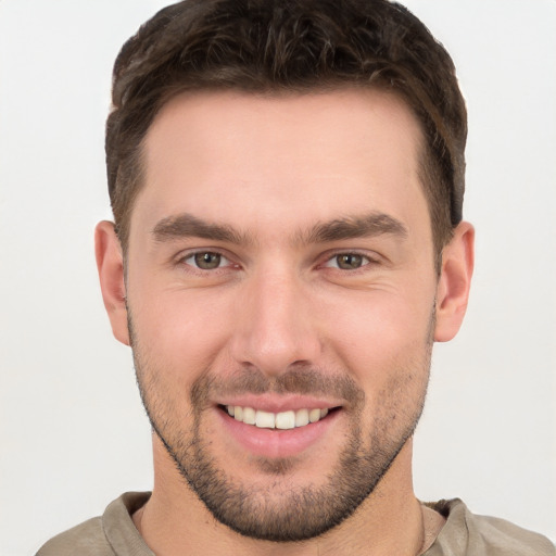 Joyful white young-adult male with short  brown hair and grey eyes