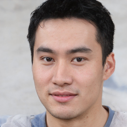 Joyful asian young-adult male with short  brown hair and brown eyes