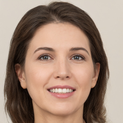 Joyful white young-adult female with long  brown hair and grey eyes