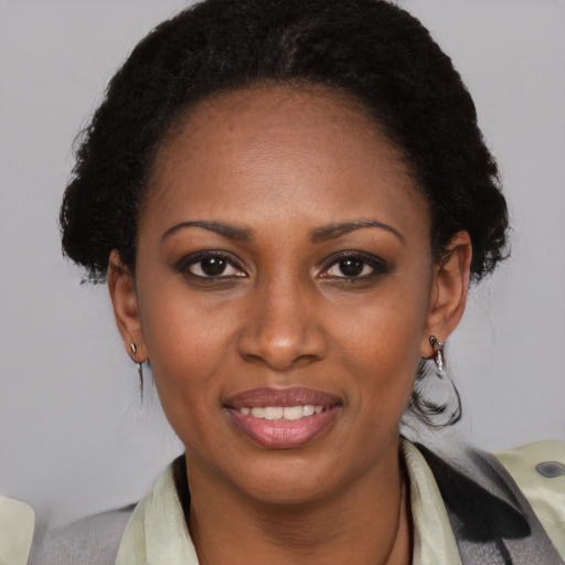 Joyful black young-adult female with short  black hair and brown eyes