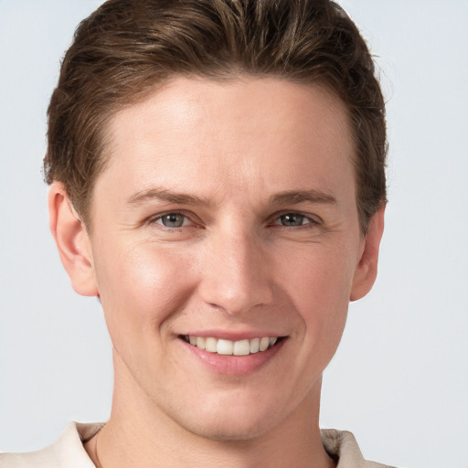 Joyful white young-adult female with short  brown hair and grey eyes