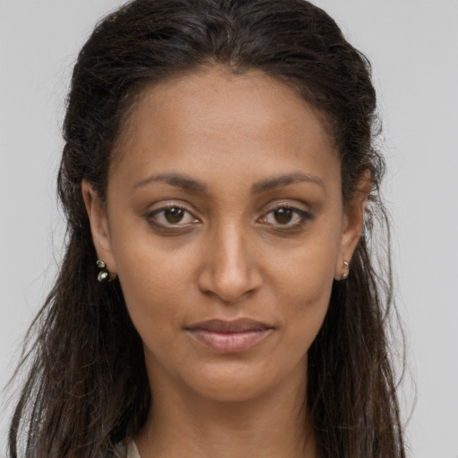 Joyful black young-adult female with long  brown hair and brown eyes