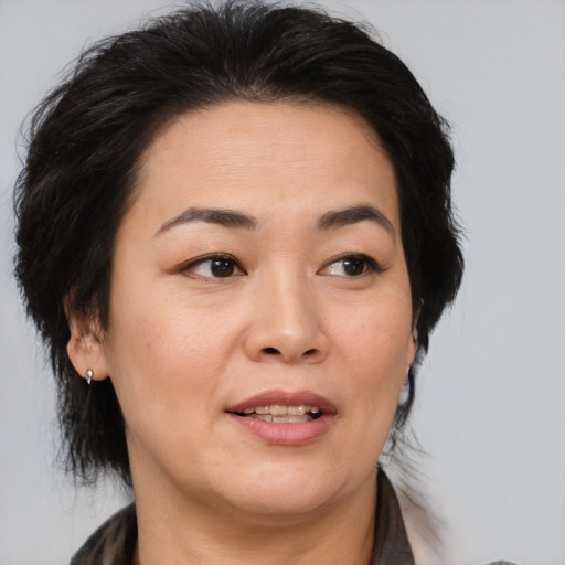 Joyful asian adult female with medium  brown hair and brown eyes