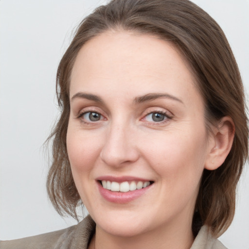 Joyful white young-adult female with medium  brown hair and grey eyes