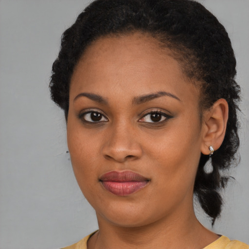 Joyful black young-adult female with medium  brown hair and brown eyes