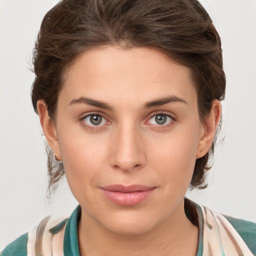 Joyful white young-adult female with medium  brown hair and green eyes