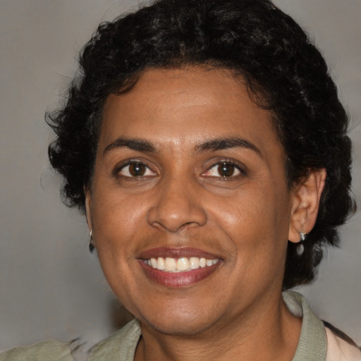 Joyful black adult female with medium  brown hair and brown eyes