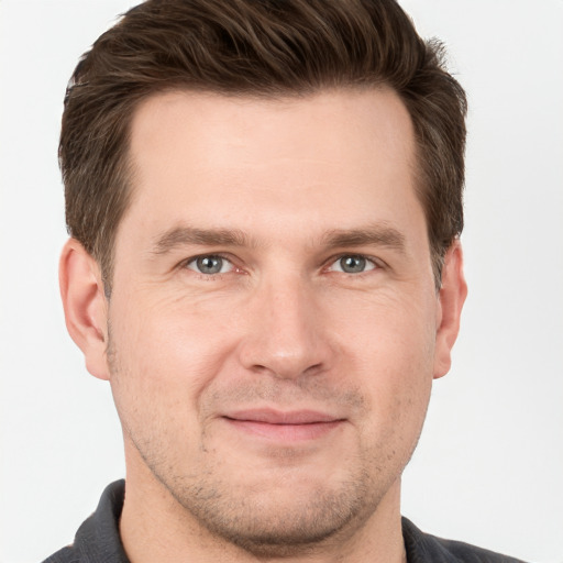 Joyful white young-adult male with short  brown hair and grey eyes