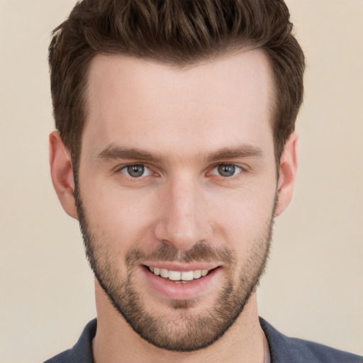 Joyful white young-adult male with short  brown hair and grey eyes