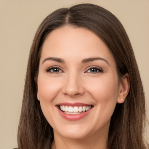 Joyful white young-adult female with long  brown hair and brown eyes