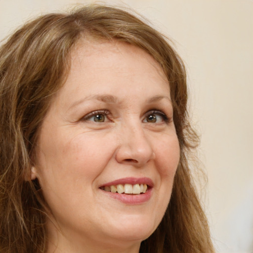 Joyful white adult female with long  brown hair and green eyes