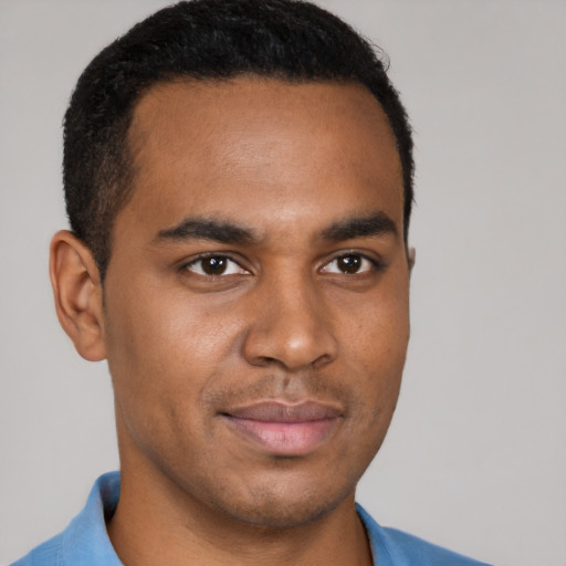 Joyful black young-adult male with short  brown hair and brown eyes