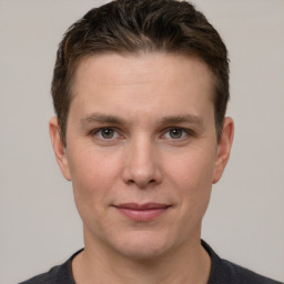 Joyful white young-adult male with short  brown hair and grey eyes