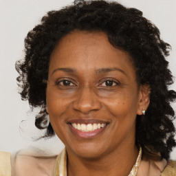 Joyful black adult female with medium  brown hair and brown eyes