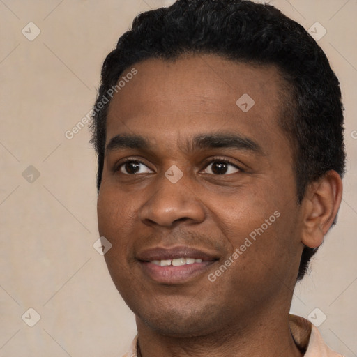 Joyful black young-adult male with short  black hair and brown eyes
