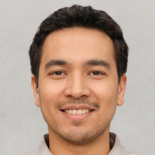 Joyful white young-adult male with short  black hair and brown eyes