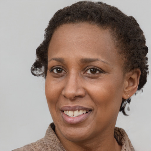 Joyful black adult female with short  brown hair and brown eyes