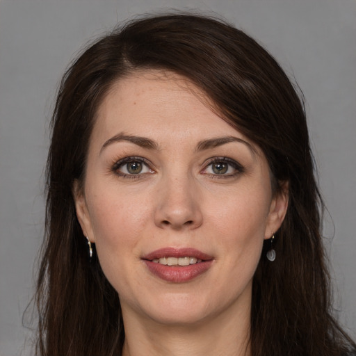 Joyful white young-adult female with long  brown hair and grey eyes