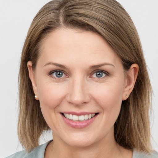 Joyful white young-adult female with medium  brown hair and grey eyes