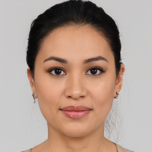 Joyful latino young-adult female with medium  brown hair and brown eyes