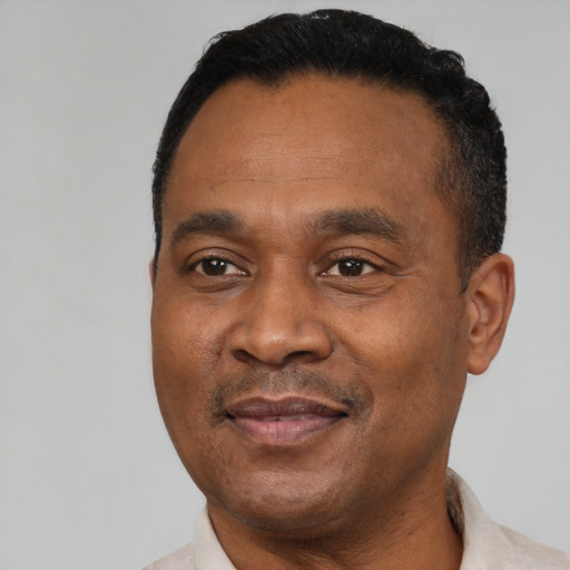 Joyful black adult male with short  black hair and brown eyes