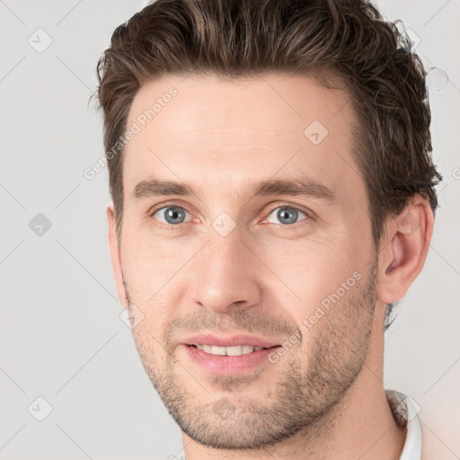 Joyful white young-adult male with short  brown hair and grey eyes