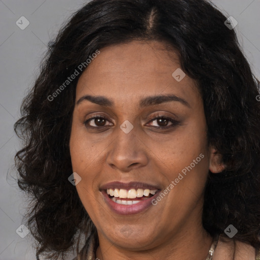 Joyful black adult female with long  brown hair and brown eyes