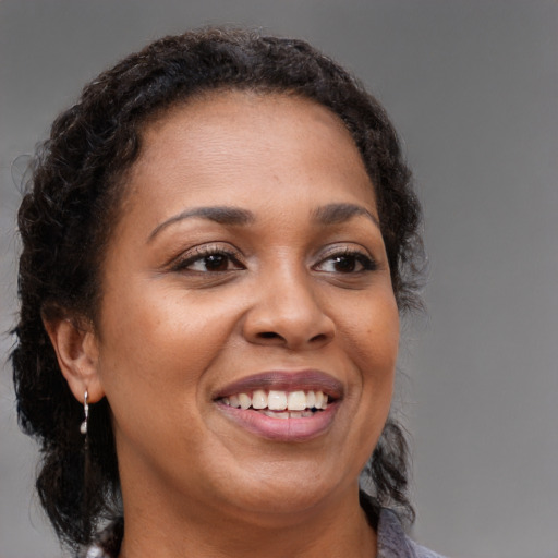 Joyful black young-adult female with medium  brown hair and brown eyes